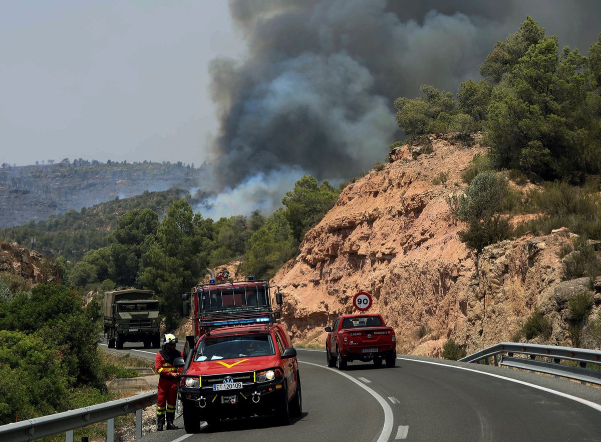 epa07677411 Emergency vehicles are seen near a forest fire in La Torre de l'Espanyol in Tarragona, Spain, 27 June 2019. Fire emergency teams work to control the flames that have already burnt 4,0 ...