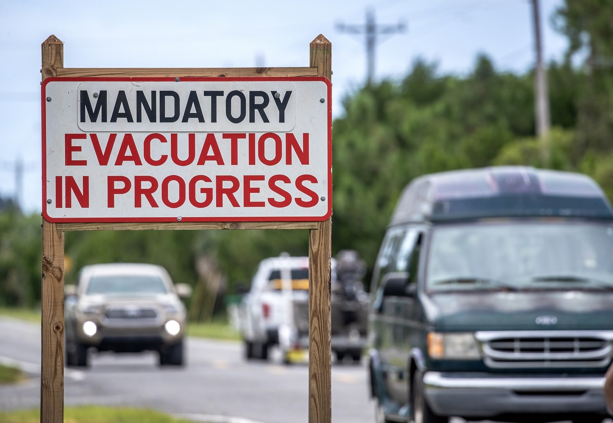Les véhicules se déplacent à côté d'un panneau «évacuation obligatoire», alors que la ville se prépare à l'ouragan Idalia, à Cedar Key, Floride, États-Unis, le 29 août 2023.