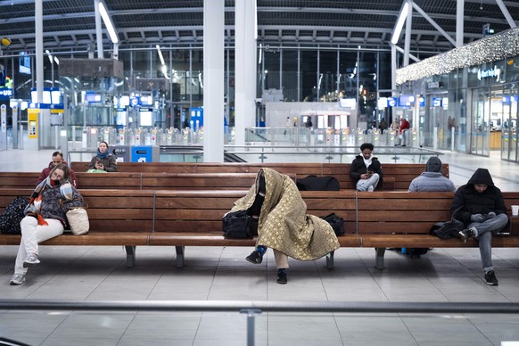 epa12630107 People sit on benches at Utrecht Central Station in Utrecht, the Netherlands, 06 January 2026. Dutch Railways (NS) train services are interrupted due to winter weather and an IT outage. EP ...