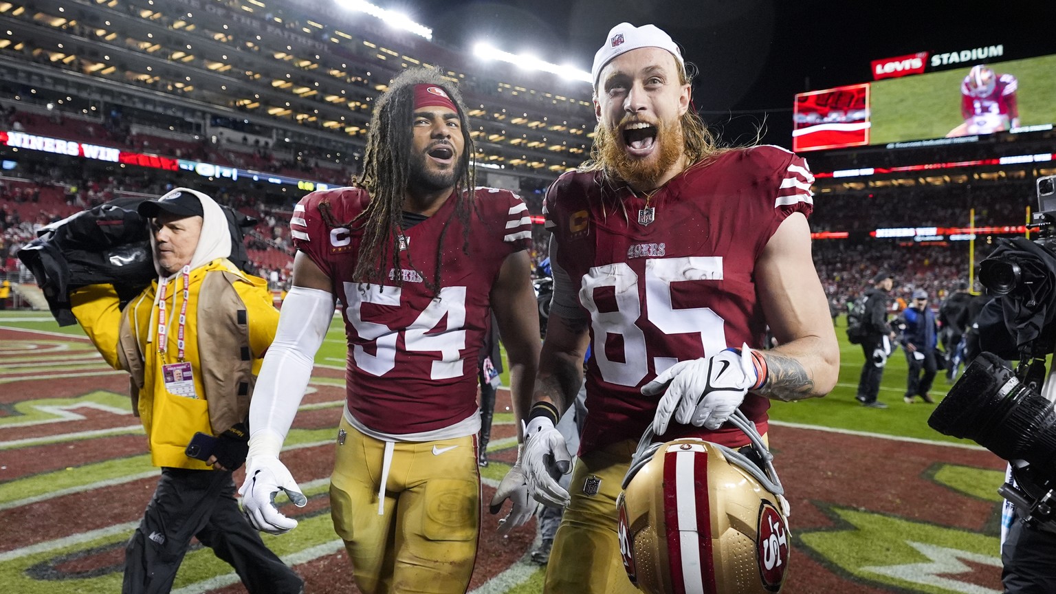 San Francisco 49ers linebacker Fred Warner (54) and tight end George Kittle (85) walk off the field after a win over the Green Bay Packers in an NFL football NFC divisional playoff game Saturday, Jan. ...