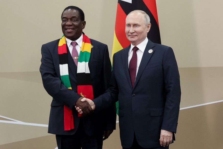 epa10771903 A handout photo made available by TASS Host Photo Agency shows Russia&#039;s President Vladimir Putin (R) and Republic of Zimbabwe&#039;s President Emmerson Dambudzo Mnangagwa (L) meet on  ...