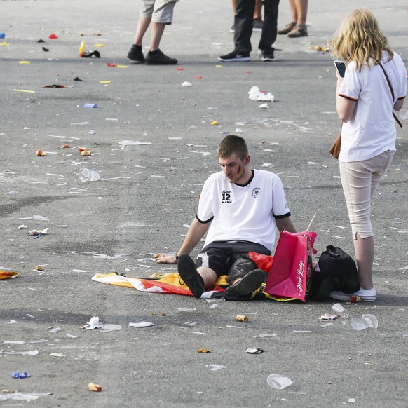 A soccer fans sits on a square during a public viewing event in Hamburg, northern Germany, Wednesday, June 27, 2018, after Germany was eliminated from the World Cup. (Ulrich Perrey/dpa via AP)