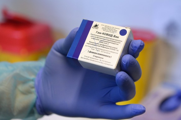 epa09021836 A vial containing Russian vaccine Sputnik V is shown by a health worker at the COVID-19 vaccination site of Semmelweis University in Budapest, Hungary, 18 February 2021. EPA/Szilard Koszti ...