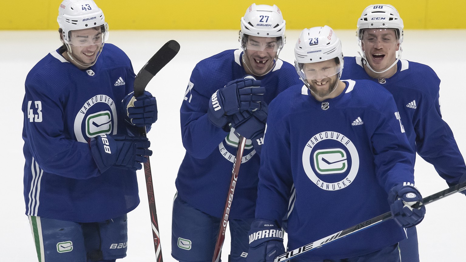 From left to right, Vancouver Canucks defensemen Quinn Hughes, Travis Hamonic, Nate Schmidt and Alexander Edler, of Sweden, laugh during the NHL hockey team's training camp in Vancouver, British ...