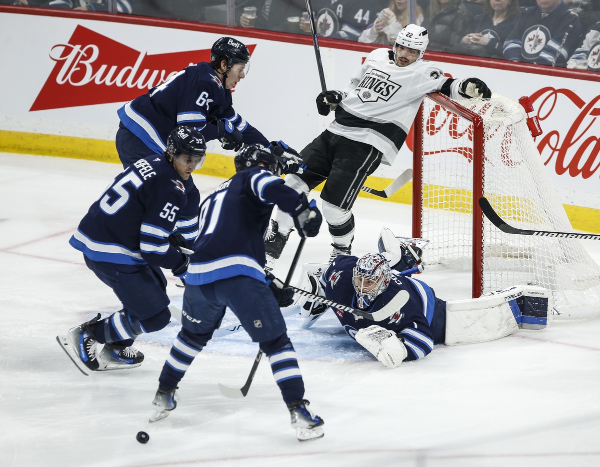 Winnipeg Jets goaltender Eric Comrie (1) watches a rebound as Los Angeles Kings' Kevin Fiala (22) crashes into the net during first-period NHL hockey game action in Winnipeg, Manitoba, Friday, Ja ...