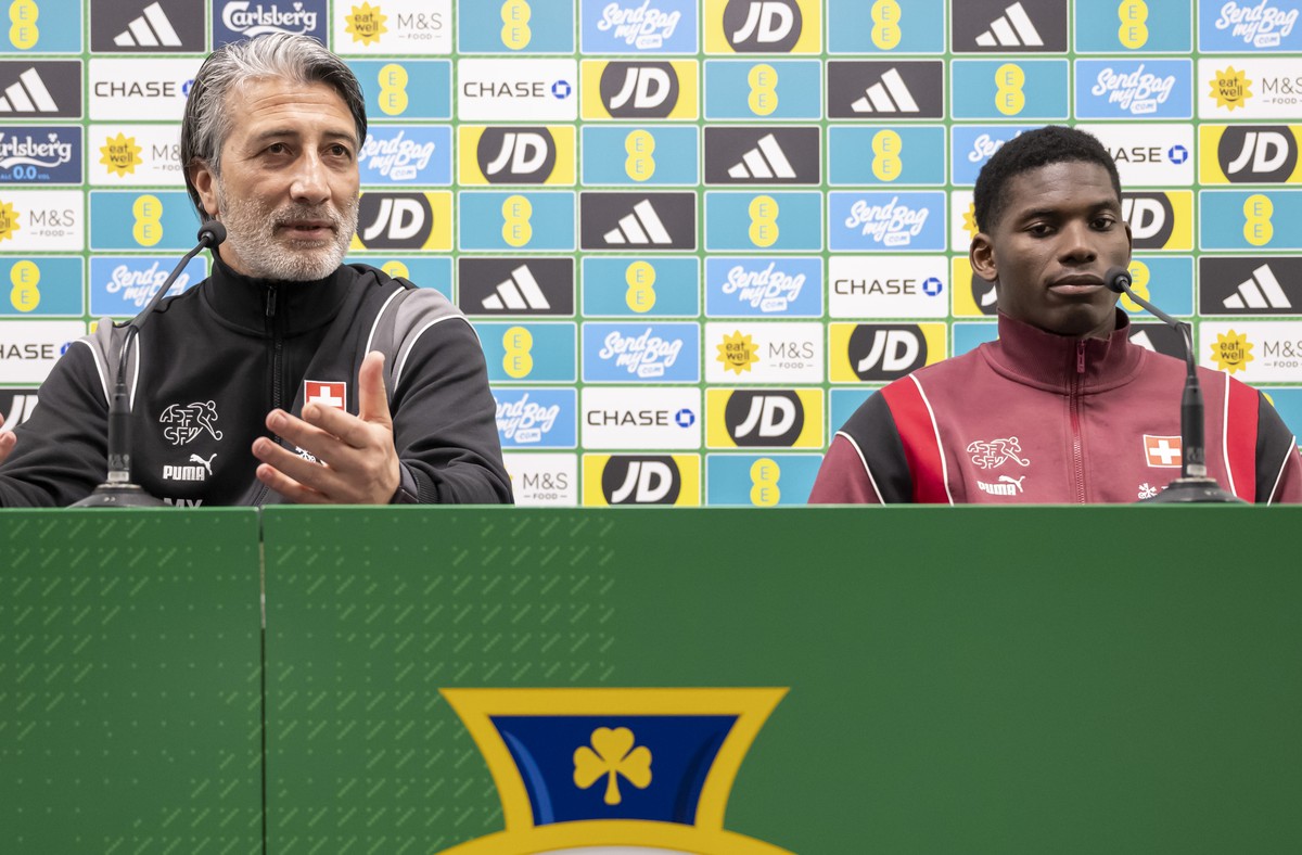 Switzerland head coach Murat Yakin, left, speaks next to Switzerland's player Breel Embolo, right, during a press conference one day prior to an international test match between Northern Ireland  ...