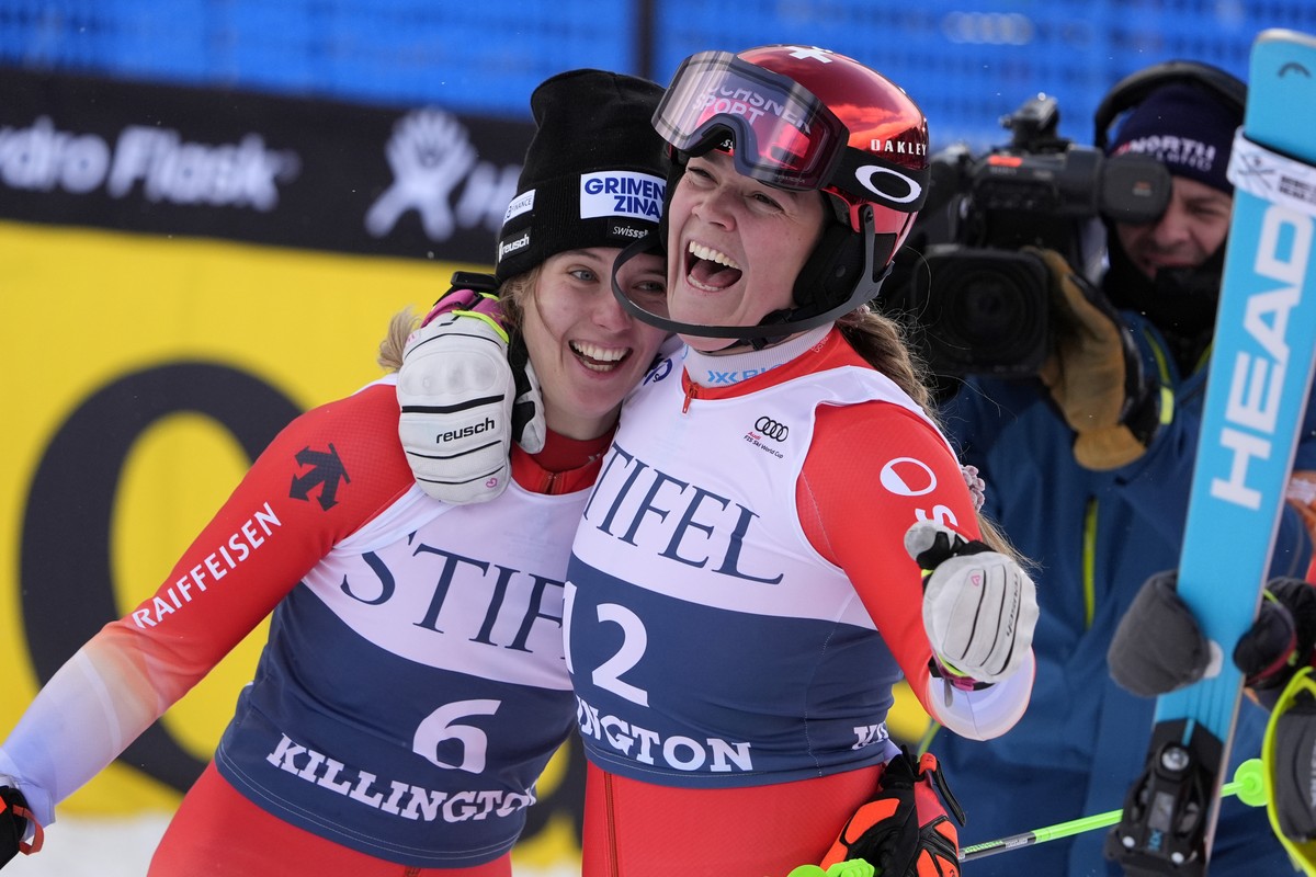 Camille Rast, of Switzerland, left, is hugged by teammate Melanie Meillard after winning a women's World Cup slalom skiing race, Sunday, Dec. 1, 2024, in Killington, Vt. (AP Photo/Robert F. Bukat ...
