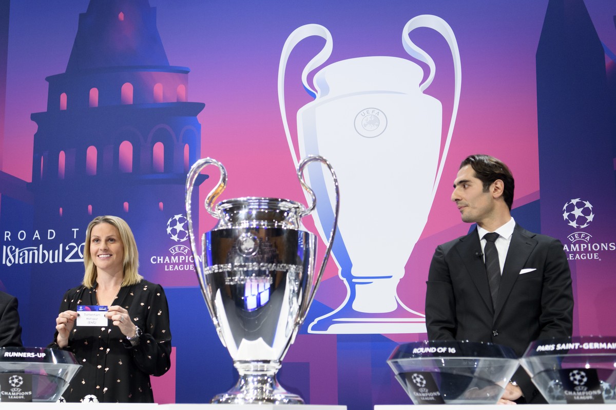 British soccer player Kelly Smith, left, shows a ticket of England's soccer club Tottenham Hotspur, next to Turkish soccer player Hamit Altõntop, right, during the UEFA Champions League 2019/20 r ...