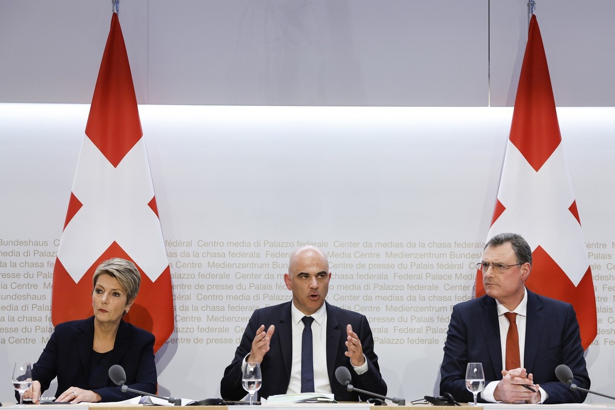 Swiss Federal President Alain Berset, center, speaks beside Swiss Finance Minister Karin Keller-Sutter, left, and Thomas J. Jordan, Chairman Swiss National Bank, during a press conference, on Sunday,  ...