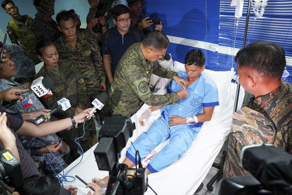 epa11424311 A handout photo made available by the Armed Forces of the Philippines (AFP) shows AFP Chief-of-Staff Gen. Romeo Brawner Jr. pinning a medal on a Navy personnel at a facility in Palawan pro ...