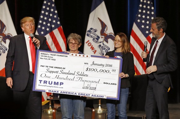 FILE - In this Jan. 31, 2016 file photo, Donald Trump, left, stages a check presentation with an enlarged copy of a $100,000 contribution from the Donald J. Trump Foundation to Support Siouxland Soldi ...