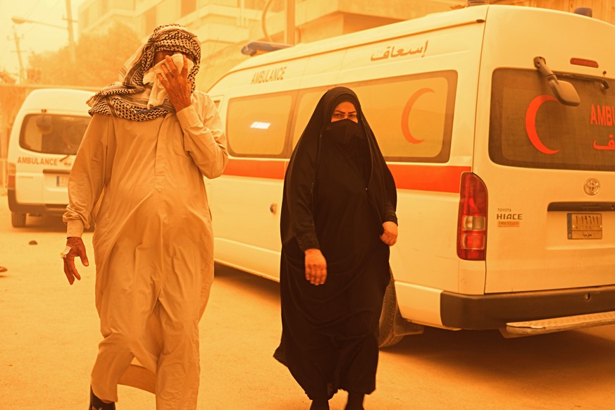 People walk on a street during a sandstorm in Baghdad, Iraq, Monday, May 16, 2022. (AP Photo/Hadi Mizban)