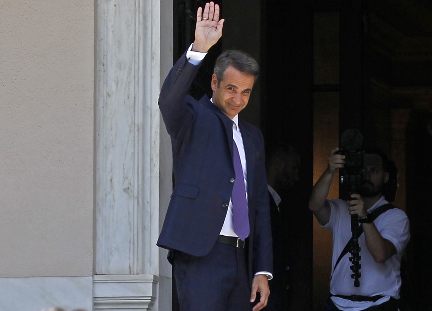 epa07703263 Newly appointed Prime Minister Kyriakos Mitsotakis waves to the outgoing Prime Minister Alexis Tsipras (not pictured) outside Maximos Mansion in Athens, Greece, 08 July 2019. New Democracy ...