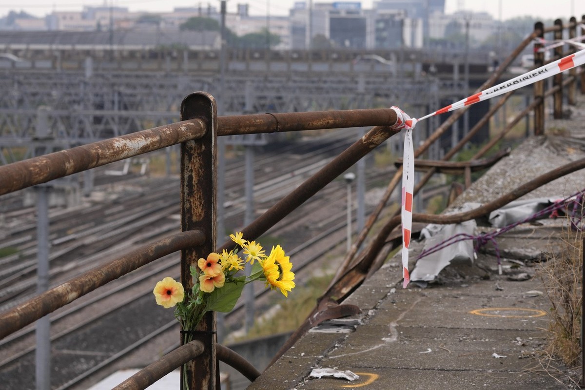 A bunch of plastic flowers is seen at the scene of a passenger bus accident in Mestre, near the city of Venice, Italy, Wednesday, Oct. 4, 2023. The bus fell from an elevated road, late Tuesday, killin ...