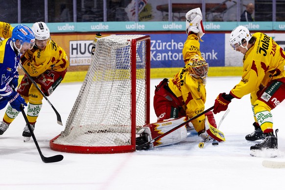 EHC Kloten Stuermer Axel Simic gegen SCL Tigers Verteidiger Juuso Riikola, Torhueter Luca Boltshauser und Verteidiger Brian Zanetti waehrend dem Play-In Runde 1 Spiel 2 Eishockey-Meisterschaftsspiel d ...