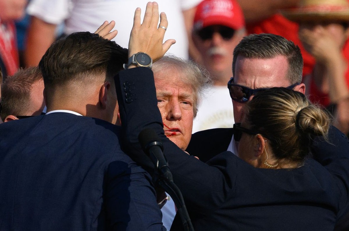 BUTLER, PENNSYLVANIA - JULY 13: Secret Service agents surround Republican presidential candidate former President Donald Trump onstage after he was injured at a rally on July 13, 2024 in Butler, Penns ...