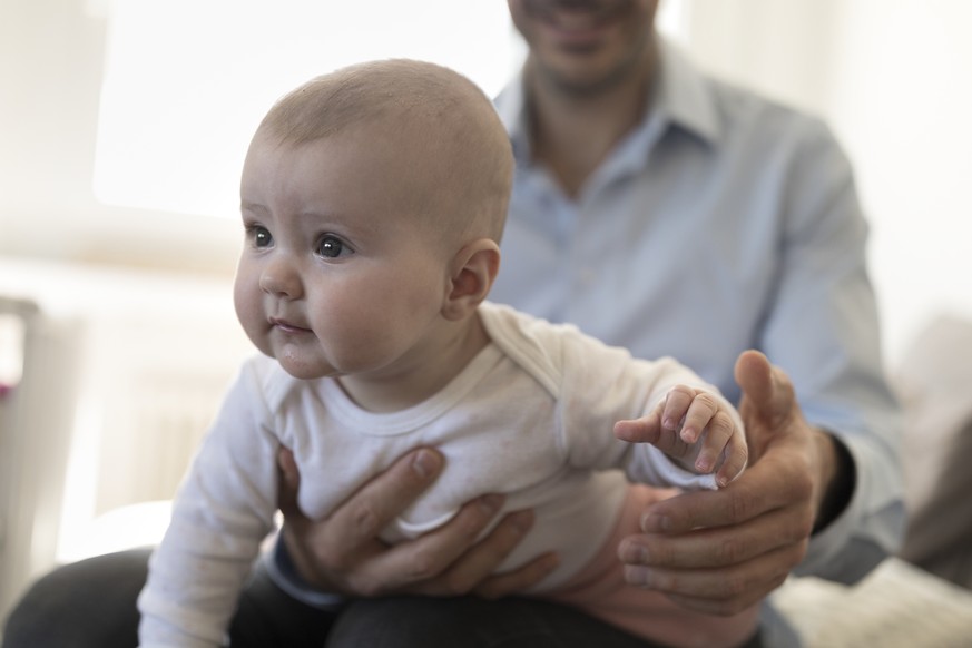 ZUM THEMA VATERSCHAFTSURLAUB STELLEN WIR IHNEN HEUTE, MITTWOCH, 25. OKTOBER 2017, FOLGENDES BILDMATERIAL ZUR VERFUEGUNG --- A father sits on the sofa with his five-month-old daughter, pictured in Kilc ...