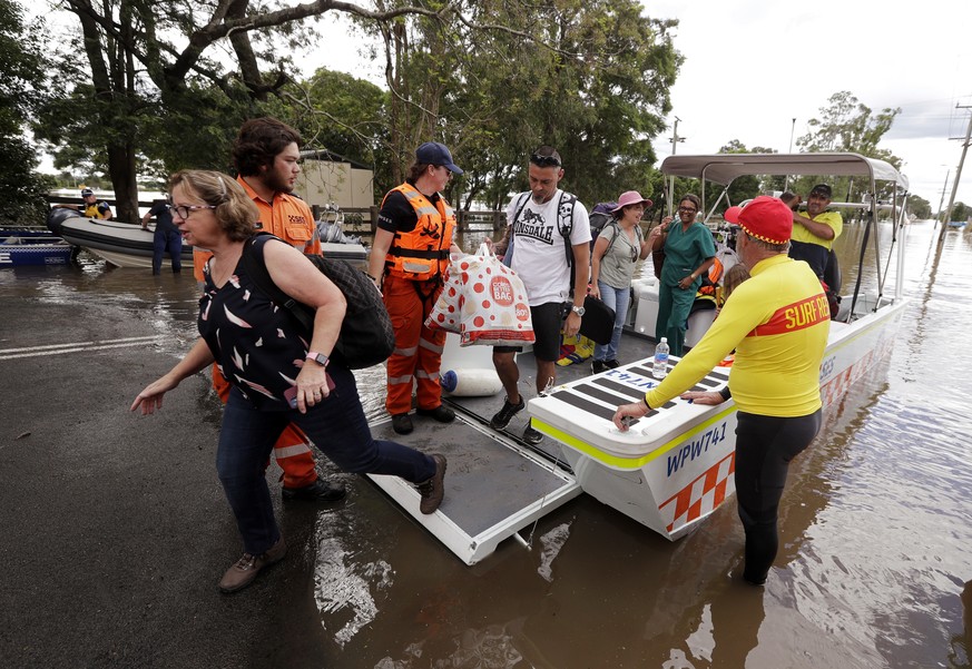People disembark a rescue boat after they were carried across the flooded Hawkesbury River in Windsor, northwest of Sydney, New South Wales, Thursday, March 25, 2021. While rain has eased across New S ...