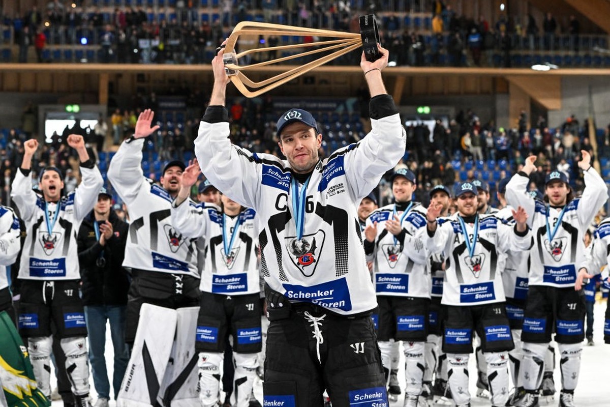 DAVOS, SWITZERLAND - DECEMBER 31: Julien Sprunger of HC Fribourg-Gotteron raises the trophy after winning the Spengler Cup Davos final match between Straubing Tigers and Fribourg-Gottéron at Eisstadio ...