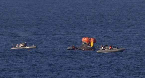 epa12881925 A handout photo made available by the National Aeronautics and Space Administration (NASA) shows NASA's Orion spacecraft floating as recovery teams work to secure the spacecraft ahead ...