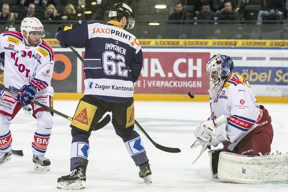 Der Zuger Stuermer Jarkko Immonen, Mitte, im Spiel gegen den Kloten Flyers Verteidiger Rene Back, links, und den Kloten Flyers Goalie Martin Gerber, rechts, im Eishockey-Meisterschaftsspiel der Nation ...