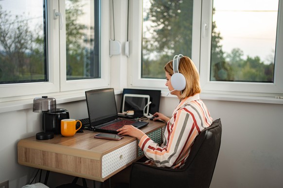 Eine Frau, die von zu Hause aus arbeitet und ein Headset trägt Eine Frau, die von zu Hause aus arbeitet und ein Headset trägt LicenseRF ,model released, Symbolfoto Copyright: xZoonar.com/JelenaxCvetko ...