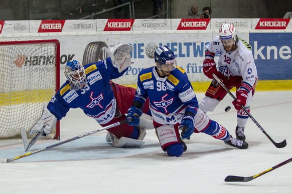 SC Rapperswil-Jona Lakers Stuermer Cedric Huesler, von rechts, gegen EHC Kloten Verteidiger Edson Harlacher und Torhueter Luca Boltshauser im dritten Eishockey Spiel der Ligaqualifikation der National ...