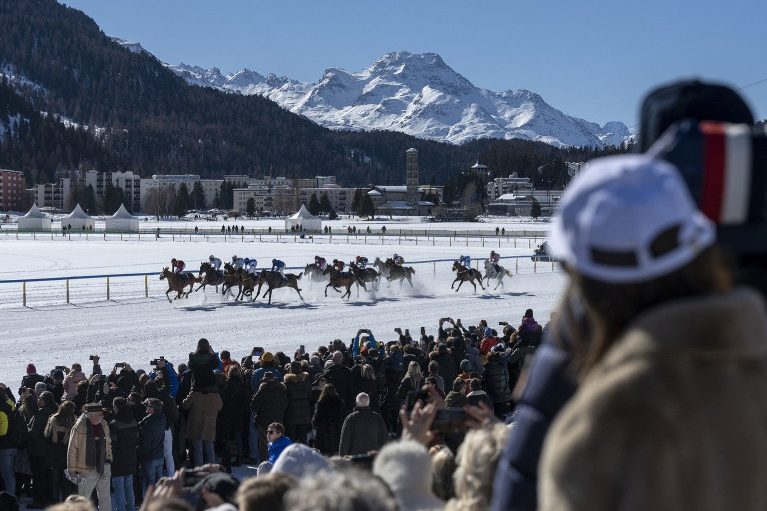 Zuschauerinnen und Zuschauer verfolgen ein Pferderennen, fotografiert im Rahmen des White Turf, am Sonntag, 20. Februar 2022 in St. Moritz. (KEYSTONE/Christian Beutler)