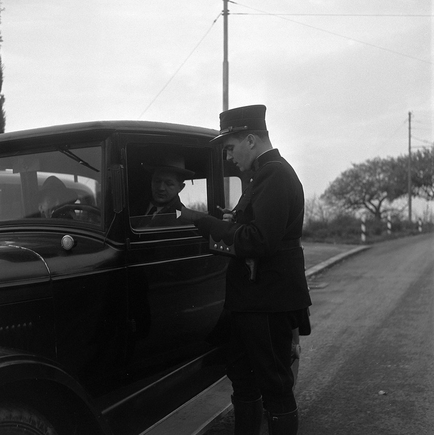 Ein Waadtländer Polizist überprüft die Papiere eines Autofahrers, um 1946.