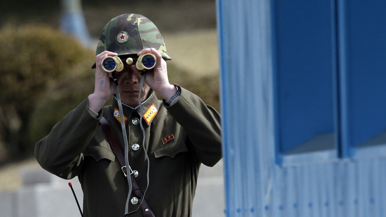 FILE - A North Korean soldier looks at the southern side through a pair of binoculars at the border village of the Panmunjom, in the Demilitarized Zone, DMZ, that separates the two Koreas since the Ko ...