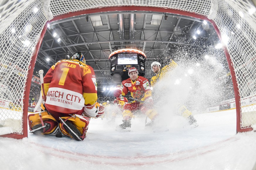 Biels Goalie Jonas Hiller, stop den Puck, an der Seite von Biels Kevin Fey, Mitte, und Davos Marc Aeschlimann, links, im ersten Eishockey Playoff-Viertelfinalspiel der National League zwischen dem HC  ...