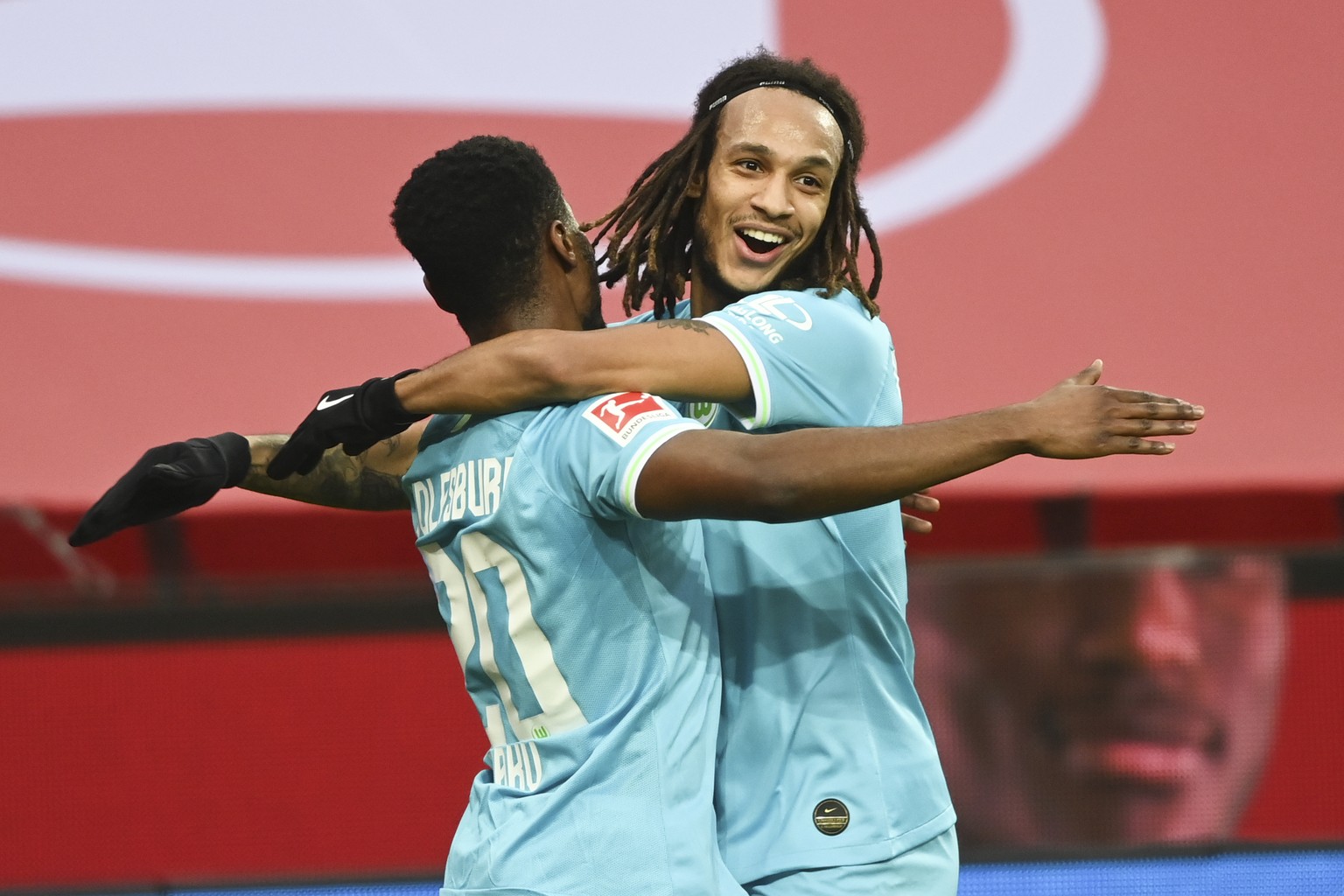 Wolfsburg&#039;s Radle Baku, left, celebrates Wolfsburg&#039;s Kevin Mbabu after scoring the opening goal during the German Bundesliga soccer match between Bayer Leverkusen and VfL Wolfsburg in Leverk ...