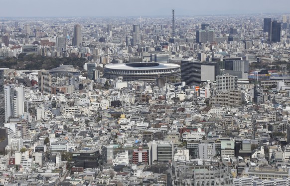 The New National Stadium, a venue designed for the opening and closing ceremonies for the Tokyo 2020 Olympics, is seen prominently at the background in Tokyo, Wednesday, March 25, 2020. (AP Photo/Koji ...