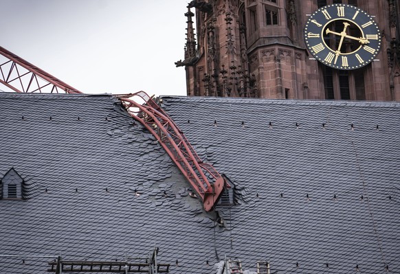The jib of a crane is seen after it fell onto the roof of Frankfurt Cathedral during a storm, in Frankfurt, Germany, Monday, Feb. 10, 2020. A storm battered the U.K. and northern Europe with hurricane-force winds and heavy rains Sunday, halting flights and trains and producing heaving seas that closed down ports. Soccer games, farmers' markets and cultural events were canceled as authorities urged millions of people to stay indoors, away from falling tree branches. (Frank Rumpenhorst/dpa via AP)
