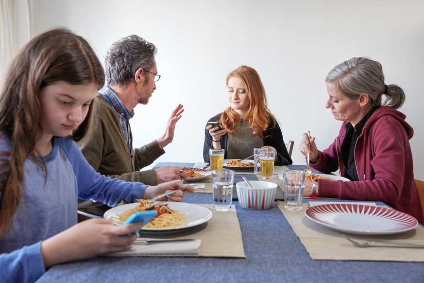 ARCHIVBILD ZUR NEUEN STUDIE VON SOMOTO ZUM THEMA STRESS IN DER SCHWEIZ, AM MONTAG, 30. OKTOBER 2017 - [Symbolic Image, Staged Picture] A family is having lunch while the daughters are using their smar ...