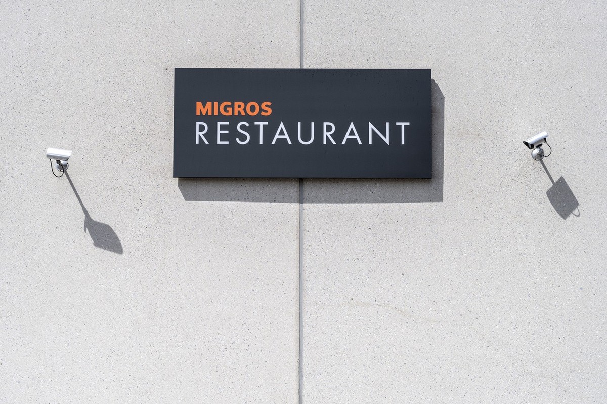 Eine Migrosrestaurant Tafel und zwei Ueberwachungskameras an der Fassade des Shoppingcenter Blauaecker, fotografiert am Mittwoch, 26. April 2023 in Koeniz. (KEYSTONE/Christian Beutler)