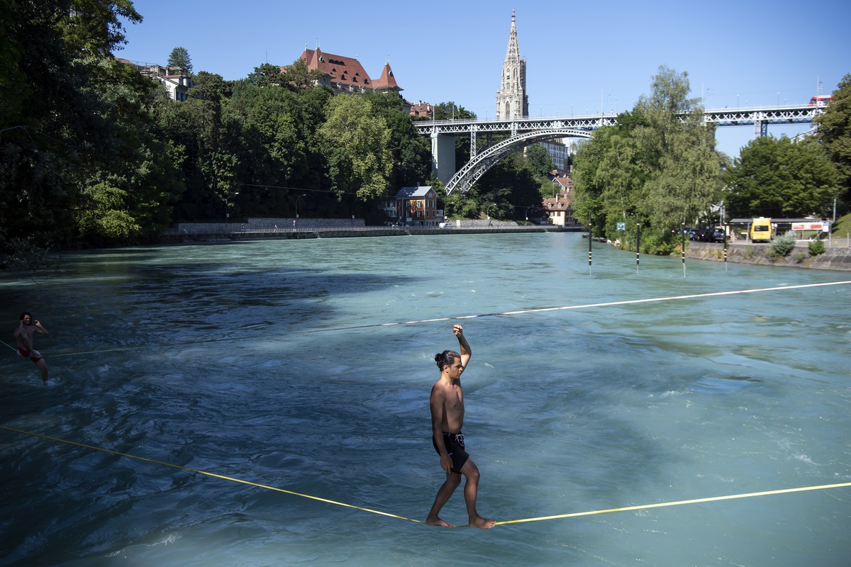 People on slacklines above the Aare river during a hot summer day, in Bern, Switzerland, Friday, June 28, 2019. The forecast predicts hot weather in Switzerland with maximum temperature at 38 degrees  ...