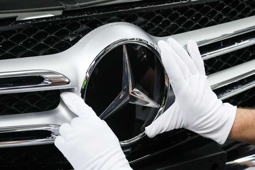 epa07486367 (FILE) - A worker attaches a Mercedes star at the C Class and GLC Class production line during a photo opportunity for the media at the Mercedes Cars factory in Bremen, northern Germany, 2 ...