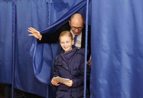 Regierungschef Arseni Jazenjuk verlässt die Abstimmungsbox mit seiner Tochter Sofia.