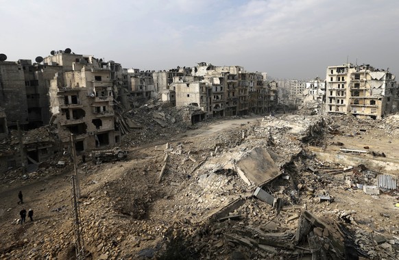FILE - In this file picture taken from the balcony of the Abdul-Hamid Khatib home, people walk through mounds of rubble which used to be high rise apartment buildings in the once rebel-held Ansari nei ...