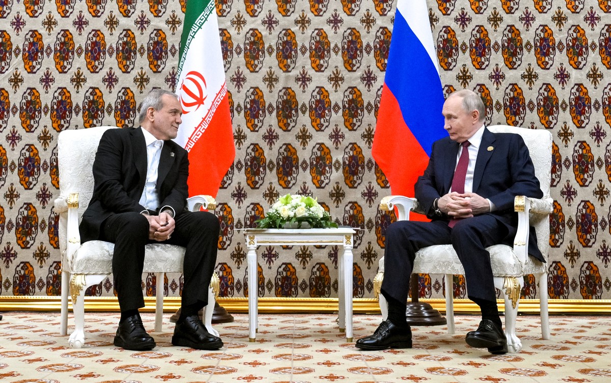 Russian President Vladimir Putin, right, and Iranian President Masoud Pezeshkian talk during their meeting on the sidelines of an international forum in Ashgabat, Turkmenistan, Friday, Dec. 12, 2025.  ...