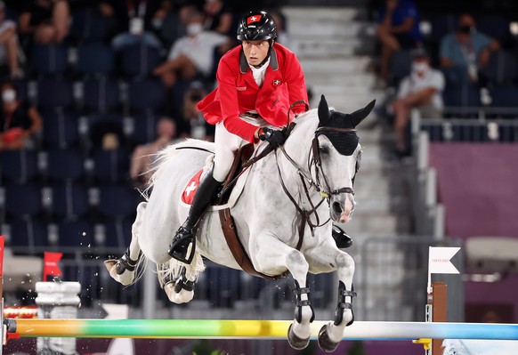 epa09400363 Martin Fuchs of Switzerland on Clooney 51 competes in the Jumping Team qualifier during the Equestrian events of the Tokyo 2020 Olympic Games at the Baji Koen Equestrian Park in Setagaya,  ...