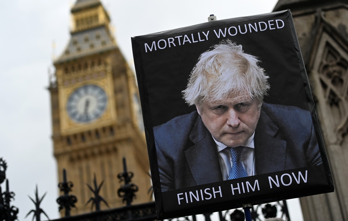 epa09999421 A protester holds up an anti Boris Johnson placard outside parliament in London, Britain, 06 June 2022. British Prime Minister Boris Johnson is facing a 'vote of no confidence' t ...