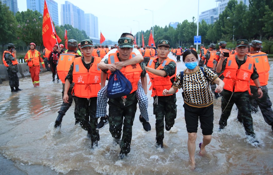 epa09358203 Rescuers evacuate people from a hospital where about 3,000 people were trapped by the flood in Zhengzhou, central China&#039;s Henan province, 22 July 2021. Thirty-three people were found  ...