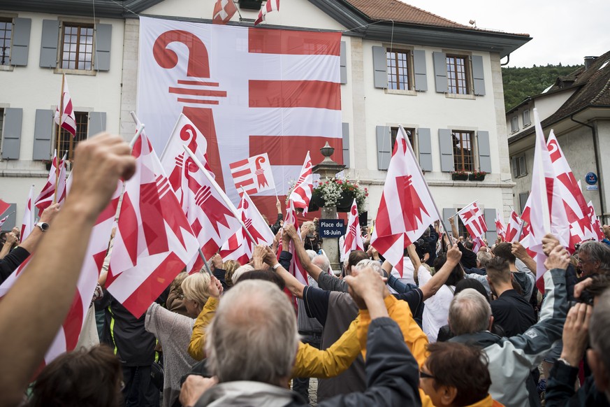 Des personnes forment une chaine humaine afin de transporter la plaque de « La place 18 juin » lors de la fete de la Liberte ce samedi 15 juin 2019 devant l’Hotel de Ville a Moutier. (KEYSTONE/Jean-Ch ...