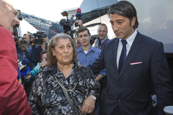 Murat Yakin, right, head coach of Switzerland&#039;s soccer team FC Basel, and his mother Emine, left, on their way to the bus in Bucharest, one day before the UEFA Champions League group E soccer mat ...