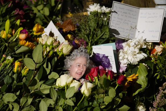 A portrait of Queen Elizabeth II is placed with flowers and messages at the Green Park memorial, near Buckingham Palace, in London, Saturday, Sept. 10, 2022. Queen Elizabeth II, Britain&#039;s longest ...