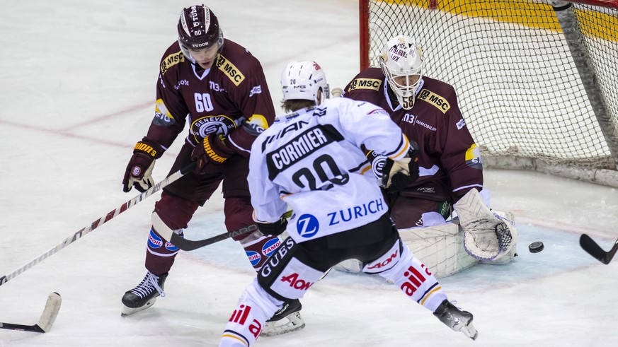 Le defenseur genevois Juluis Honka, gauche, a la lutte pour le puck avec l&#039;attaquant luganais Cole Cormier, centre, devant le gardien genevois Jussi Olkinuora, droite, lors du match du championna ...