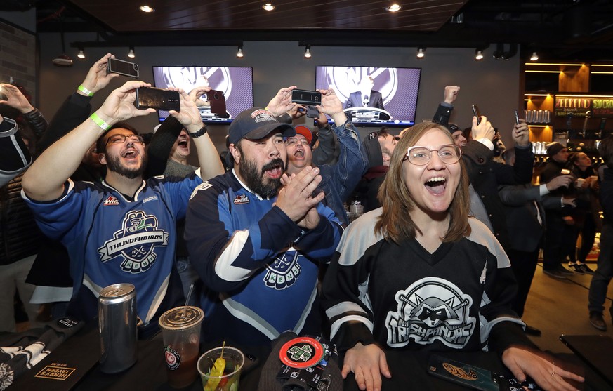 Ryan Kelly, left, Otto Rogers and Rebecca Moloney cheer the announcement of a new NHL hockey team in Seattle at a celebratory party Tuesday, Dec. 4, 2018, in Seattle. The NHL Board of Governors unanim ...