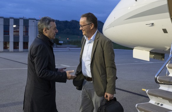 epa10590104 Swiss Federal Councilor Ignazio Cassis (L) welcomes Christian Winter, Swiss Ambassador of Sudan, as Swiss nationals are flown out of the crisis area in Sudan, at the Bern-Belp Airport in B ...